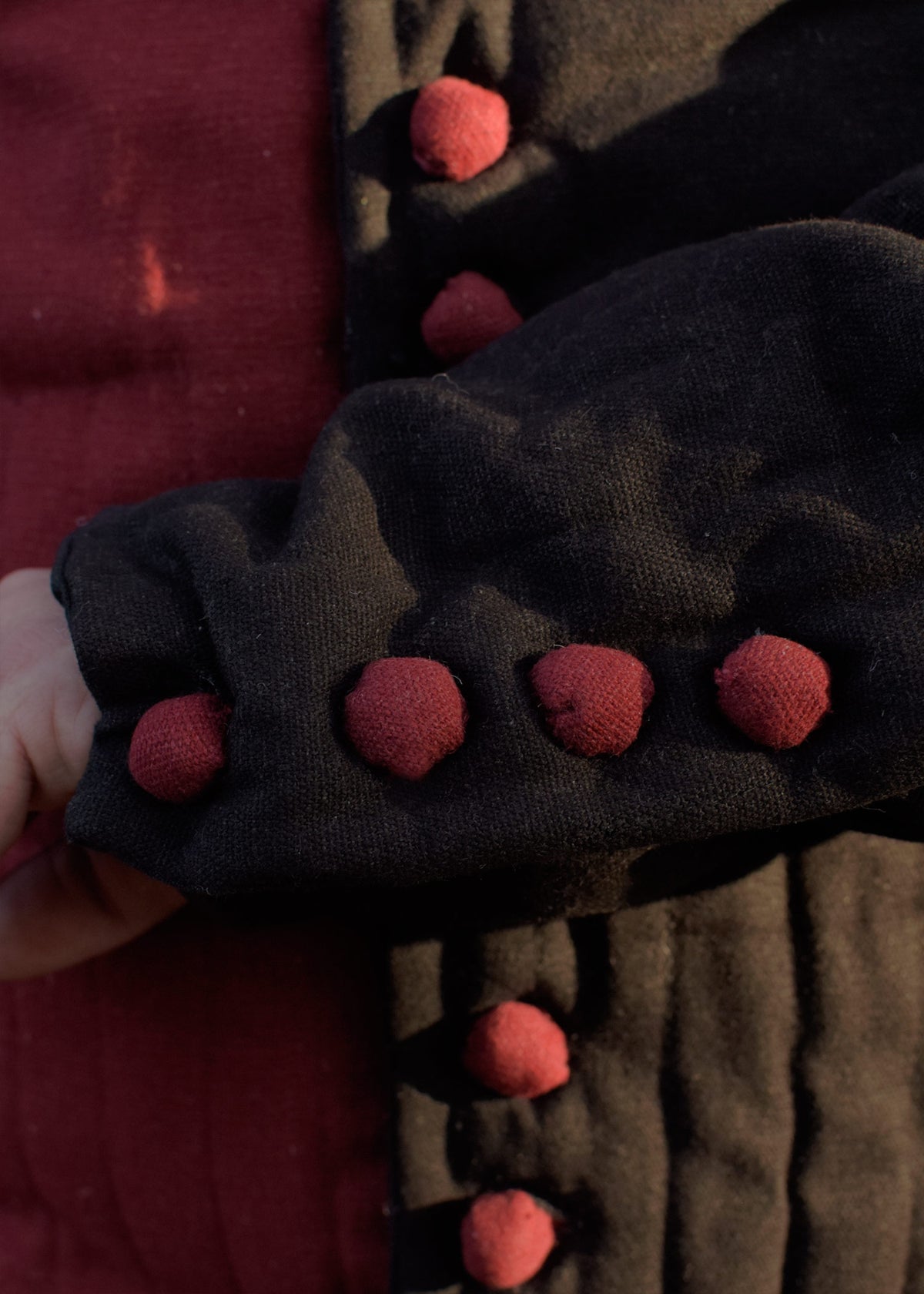 Jupon matelassé médiéval rouge et noir à boutons d'étoffe
